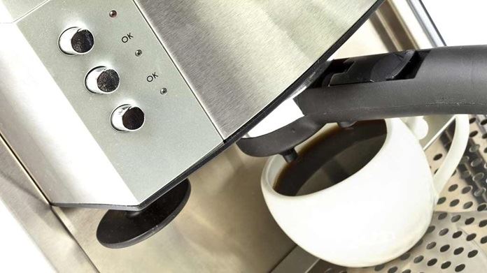 stainless coffee machine pouring espresso.jpg